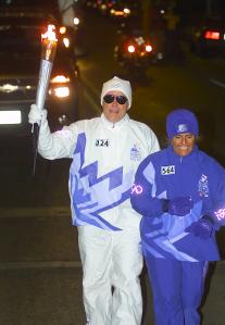 Picture of Greg Mark carrying the Olympic Torch in the 2002 Olympic Torch Relay.